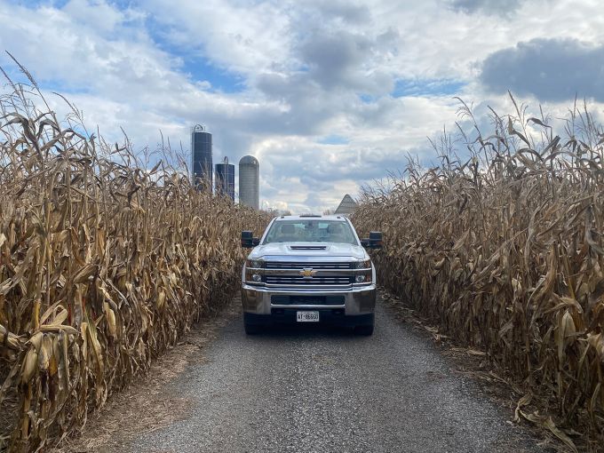 Harvex Truck on road surrounded by silos and wheat fields